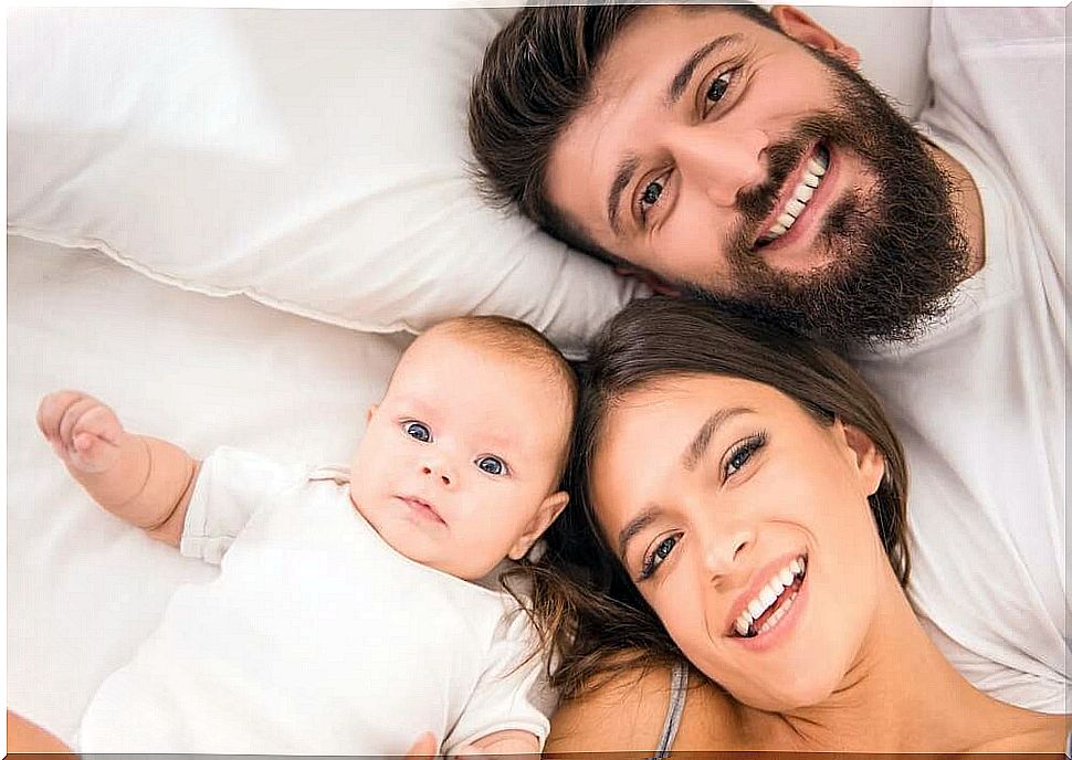 First-time parents with child in bed