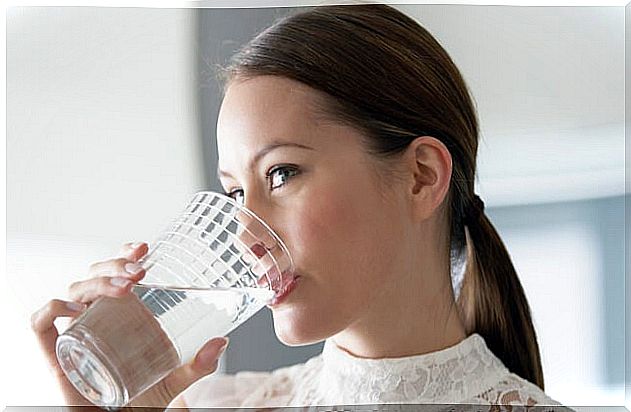 Woman drinking water to eliminate liquids