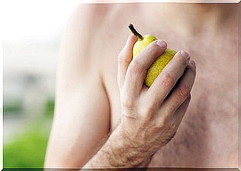 man holding a fruit to eat