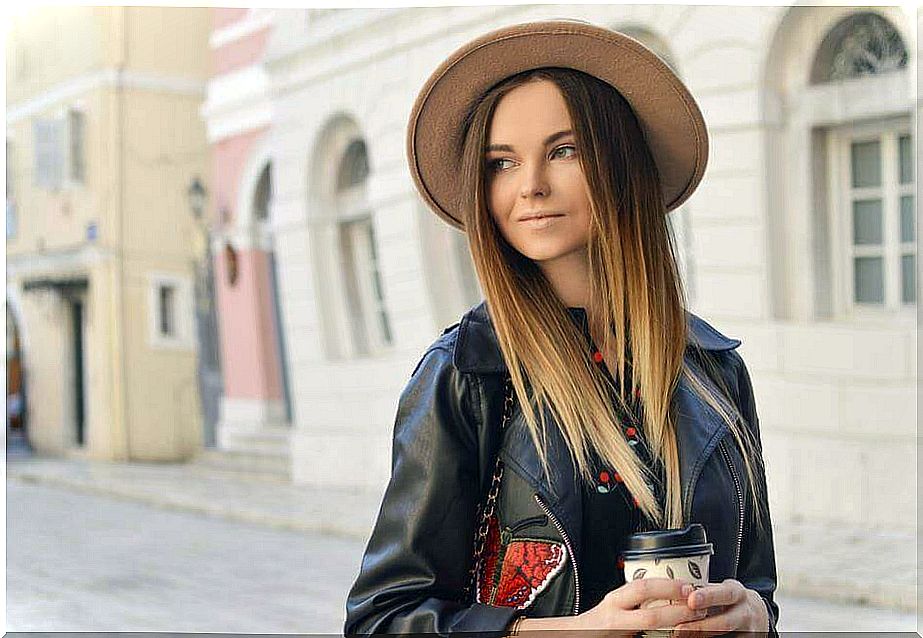 Woman wearing leather jacket and hat.